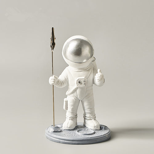 astronaut memo clip holding a desk note